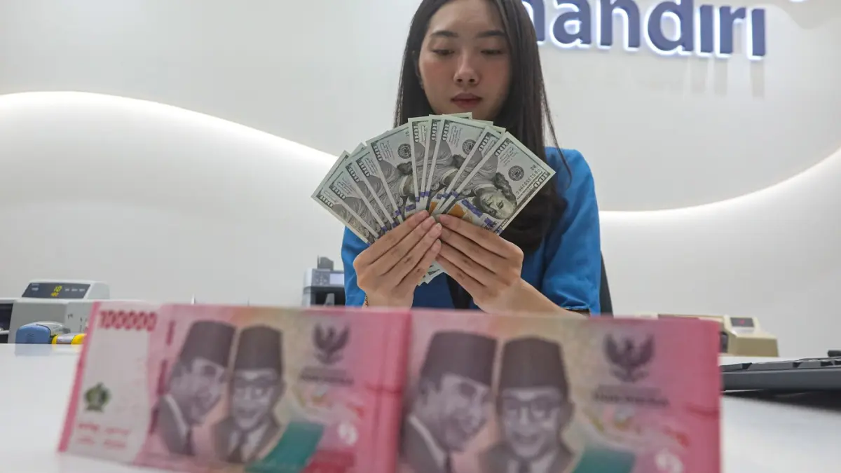 Teller menunjukan mata uang Dolar AS dan Rupiah di salah satu kantor cabang Bank Mandiri di Jakarta, Senin (9/3/2026). (Salman Toyibi/Jawa Pos)