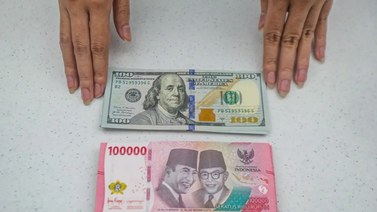 Teller menunjukan mata uang Dolar AS dan Rupiah di salah satu kantor cabang Bank Mandiri di Jakarta, Senin (9/3/2026). (Salman Toyibi/Jawa Pos)