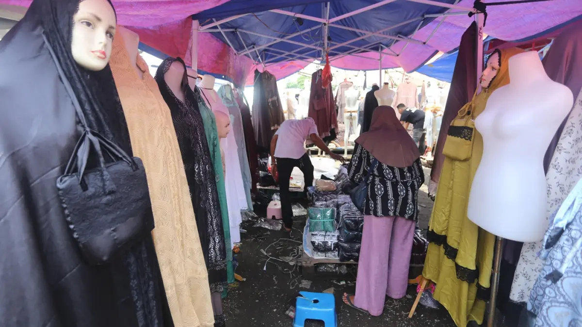 Pembeli saat memilih baju yang dijual di Pasar Tasik, Cideng, Jakarta Pusat. Di Pasar ini yang mayoritas menjual busana muslim ini berlangsung setiap hari Senin dan Kamis pagi dari pukul 05.00 WIB-13.00 WIB.  (Dery Ridwansah/ JawaPos.com) 