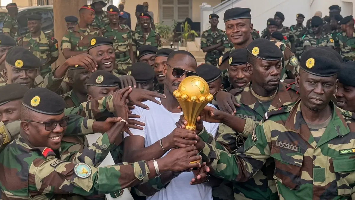 Video Lama Pelatih Senegal Bawa Trofi AFCON ke Markas Militer Kembali Viral Usai Gelar Juara Dicabut, Begini Faktanya - Image