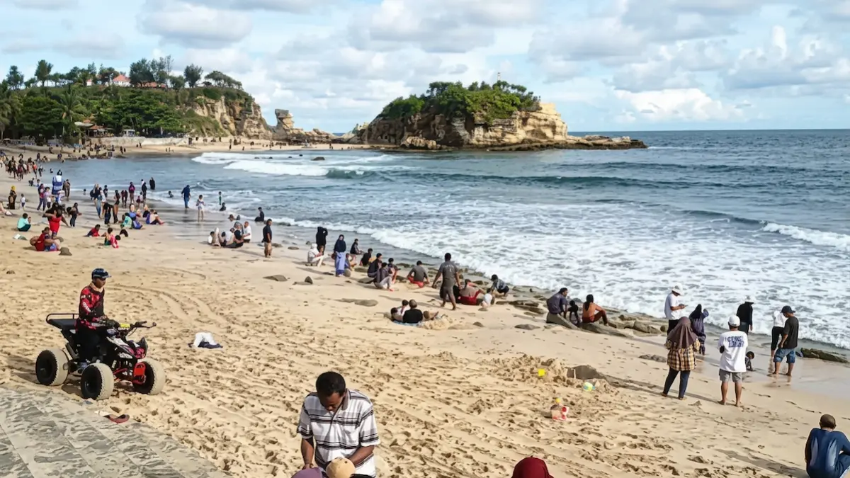Suasana Pantai Klayar Pacitan dipadati wisatawan saat libur Lebaran 2026 dengan latar seruling laut yang ikonik. (Nur CahyonoRadar Pacitan) - Image