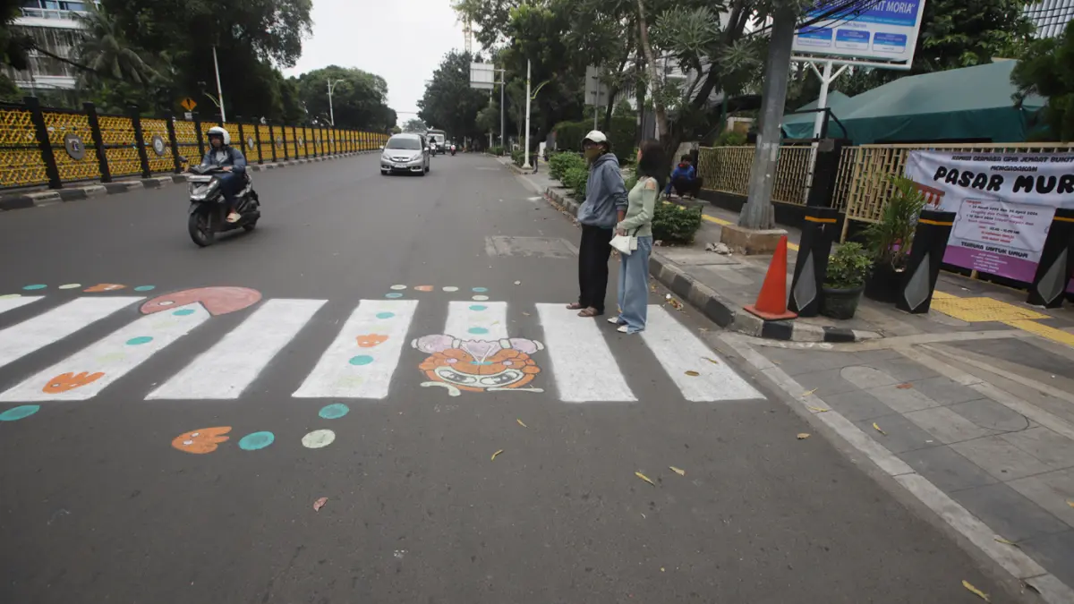 Pengguna jalan melintasi zebra cross buatan warga di Jalan Soepomo, Pancoran, Jakarta, Minggu (29/3/2026). (Dery Ridwansah/ JawaPos.com)