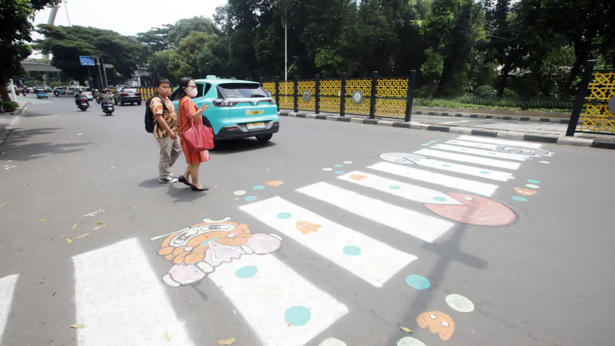 Pengguna jalan melintasi zebra cross buatan warga di Jalan Soepomo, Pancoran, Jakarta, Minggu (29/3/2026). (Dery Ridwansah/ JawaPos.com)