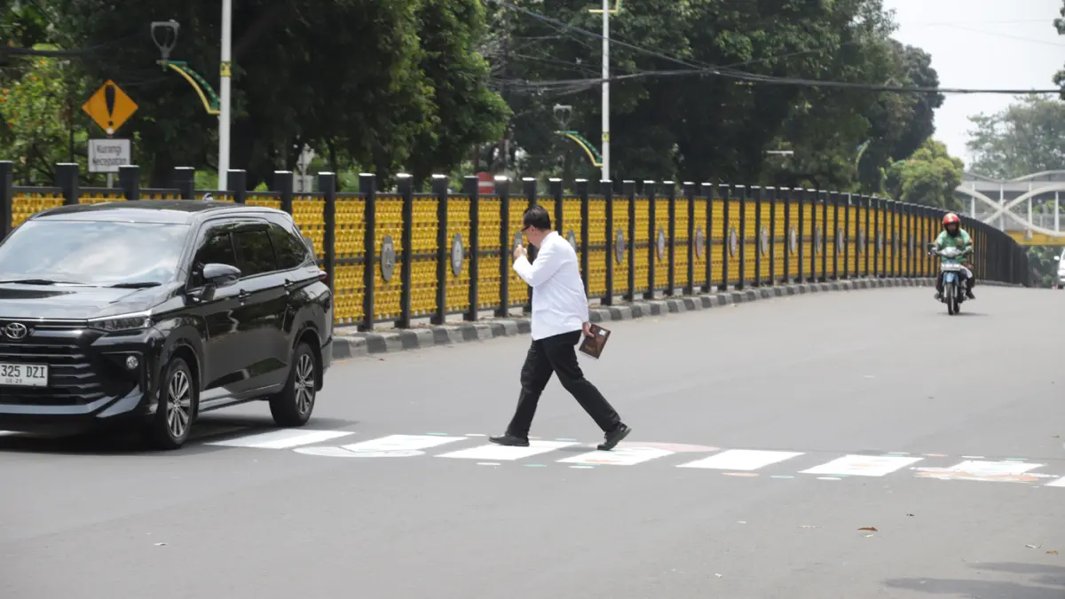 Pengguna jalan melintasi zebra cross buatan warga di Jalan Soepomo, Pancoran, Jakarta, Minggu (29/3/2026). (Dery Ridwansah/ JawaPos.com)