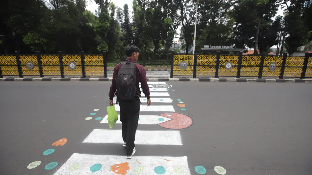 Pengguna jalan melintasi zebra cross buatan warga di Jalan Soepomo, Pancoran, Jakarta, Minggu (29/3/2026). (Dery Ridwansah/ JawaPos.com)