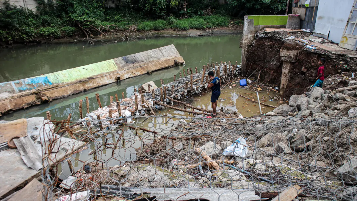 Sejumlah anak-anak bermain di lokasi ambruknya tanggul kali Angke di Rawa Buaya, Jakarta, Minggu (29/03/2026). (Hanung Hambara/Jawa Pos)