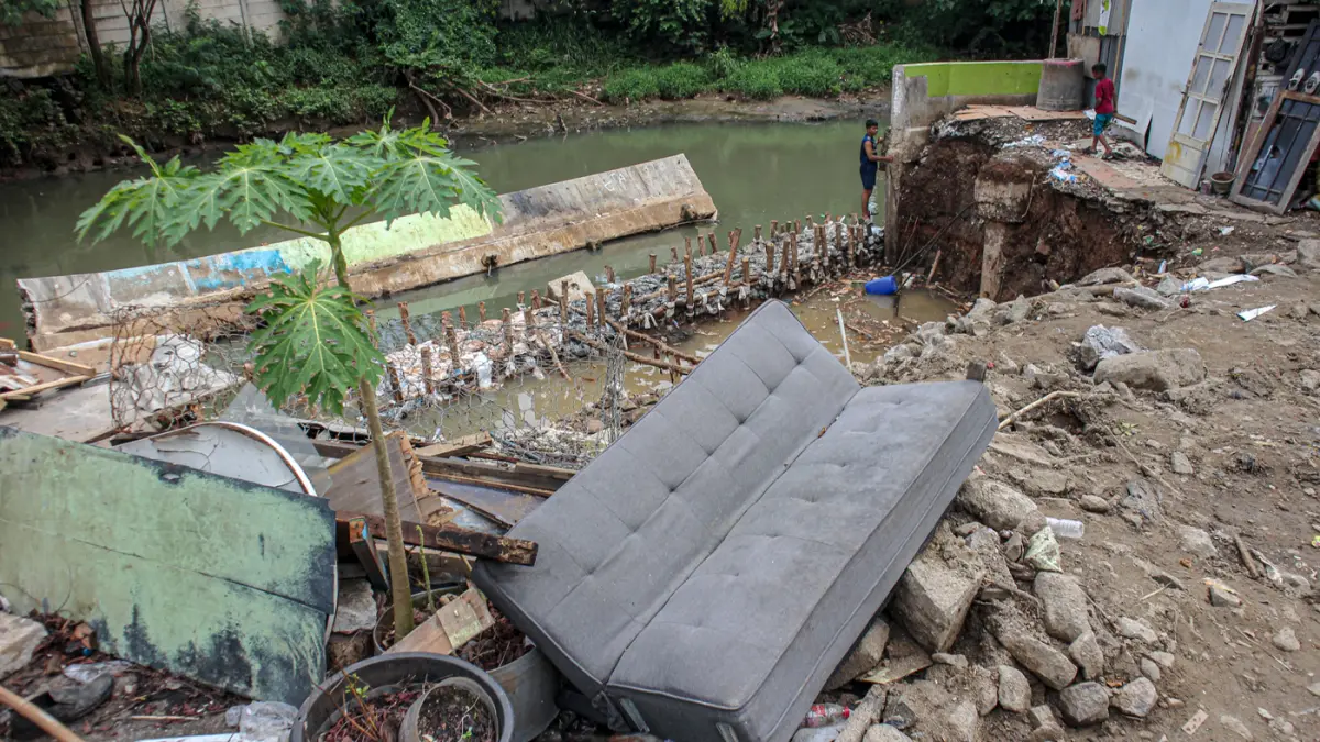 Sejumlah anak-anak bermain di lokasi ambruknya tanggul kali Angke di Rawa Buaya, Jakarta, Minggu (29/03/2026). (Hanung Hambara/Jawa Pos)
