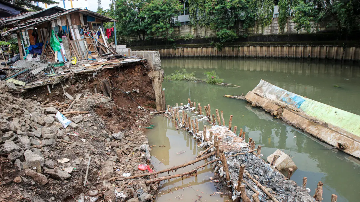 Sejumlah anak-anak bermain di lokasi ambruknya tanggul kali Angke di Rawa Buaya, Jakarta, Minggu (29/03/2026). (Hanung Hambara/Jawa Pos)