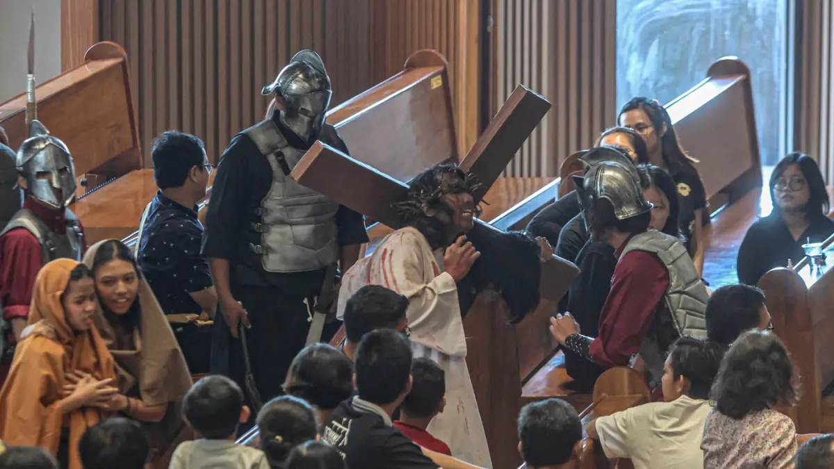 Umat Katolik menyaksikan drama penyaliban Yesus pada Tablo Jalan Salib saat peringatan Jumat Agung di Gereja Katolik Paroki Santa Bernadet, Kota Tangerang, Jumat (03/04/2026). (Hanung Hambara/Jawa Pos)