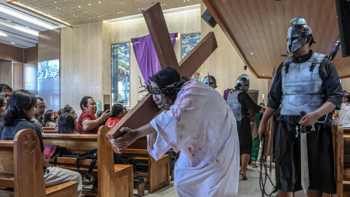 Umat Katolik menyaksikan drama penyaliban Yesus pada Tablo Jalan Salib saat peringatan Jumat Agung di Gereja Katolik Paroki Santa Bernadet, Kota Tangerang, Jumat (03/04/2026). (Hanung Hambara/Jawa Pos)