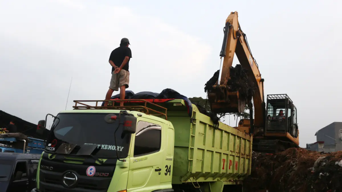 Alat berat melakukan pengangkutan gunungan sampah yang mengendap di Pasar Induk Kramat Jati, Jakarta Timur, Selasa (7/4/2026). (Dery Ridwansah/ JawaPos.com)