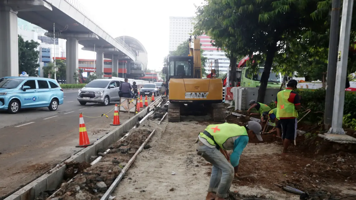 Pekerja menyelesaikan proyek revitalisasi trotoar di Jalan H.R. Rasuna Said, Jakarta, Rabu (8/4/2026). (Dery Ridwansah/ JawaPos.com)