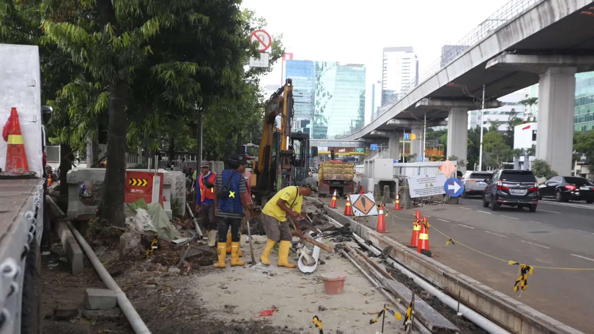 Pekerja menyelesaikan proyek revitalisasi trotoar di Jalan H.R. Rasuna Said, Jakarta, Rabu (8/4/2026). (Dery Ridwansah/ JawaPos.com)