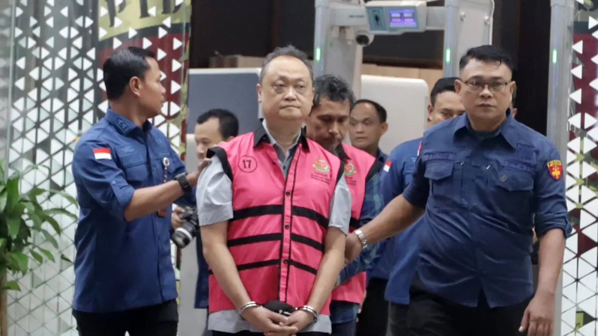 Petugas mendampingi tersangka perkara dugaan pengadaan minyak mentah dan produk kilang Irawan Prakoso usai menjalani pemeriksaan di Kejaksaan Agung, Jakarta, Kamis (9/4/2026). (Dery Ridwansah/ JawaPos.com)