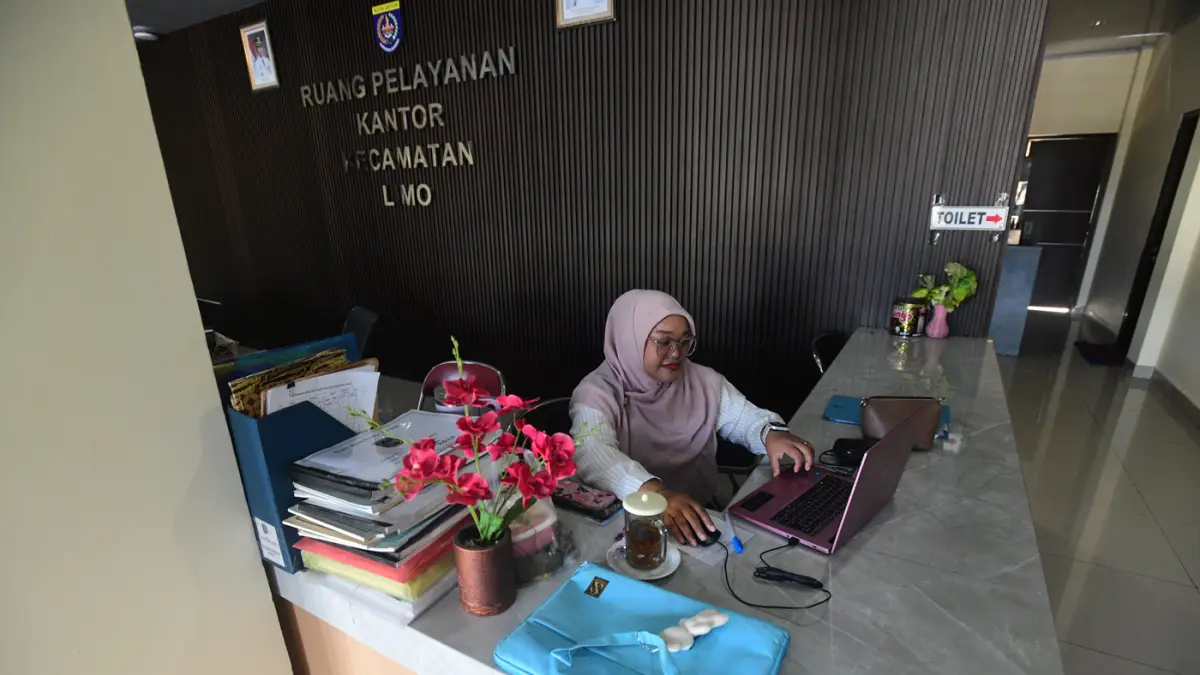 Staf bekerja di depan komputer dengan beberapa meja kursi yang kosong saat penerapan work from home (WFH) bagi aparatur sipil negara (ASN) di kantoir Kecamatan Limo, Depok, Jumat (10/04/2026). (Dery Ridwansah/ JawaPos.com)
