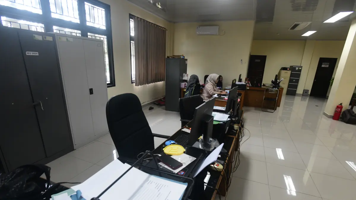 Staf bekerja di depan komputer dengan beberapa meja kursi yang kosong saat penerapan work from home (WFH) bagi aparatur sipil negara (ASN) di kantoir Kecamatan Limo, Depok, Jumat (10/04/2026). (Dery Ridwansah/ JawaPos.com)