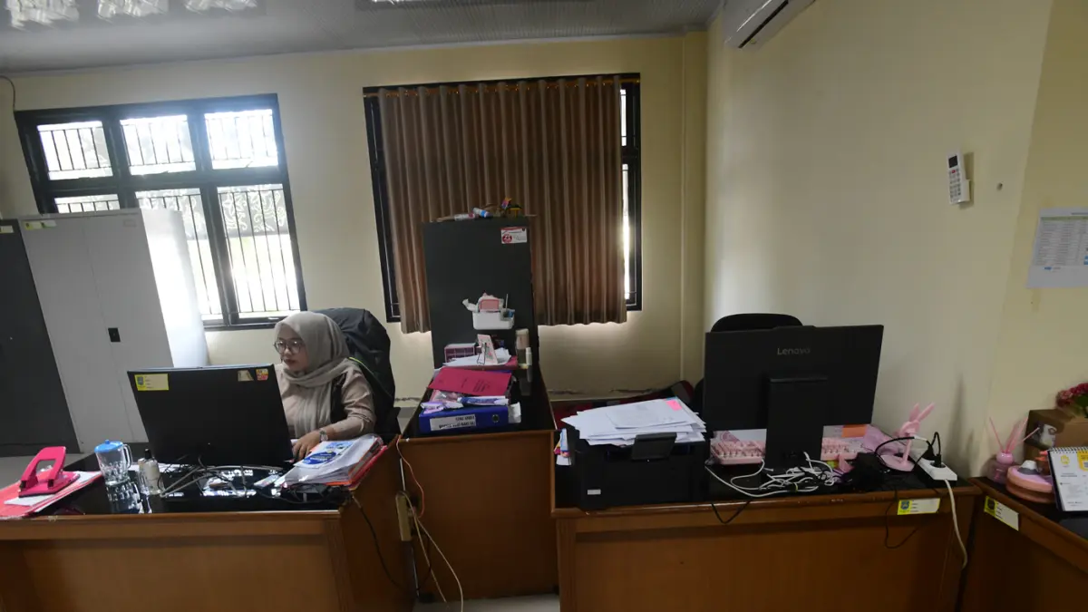 Staf bekerja di depan komputer dengan beberapa meja kursi yang kosong saat penerapan work from home (WFH) bagi aparatur sipil negara (ASN) di kantoir Kecamatan Limo, Depok, Jumat (10/04/2026). (Dery Ridwansah/ JawaPos.com)