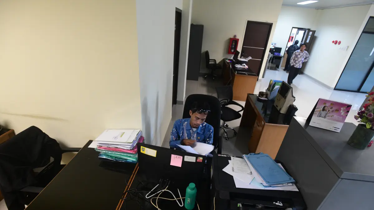 Staf bekerja di depan komputer dengan beberapa meja kursi yang kosong saat penerapan work from home (WFH) bagi aparatur sipil negara (ASN) di kantoir Kecamatan Limo, Depok, Jumat (10/04/2026). (Dery Ridwansah/ JawaPos.com)