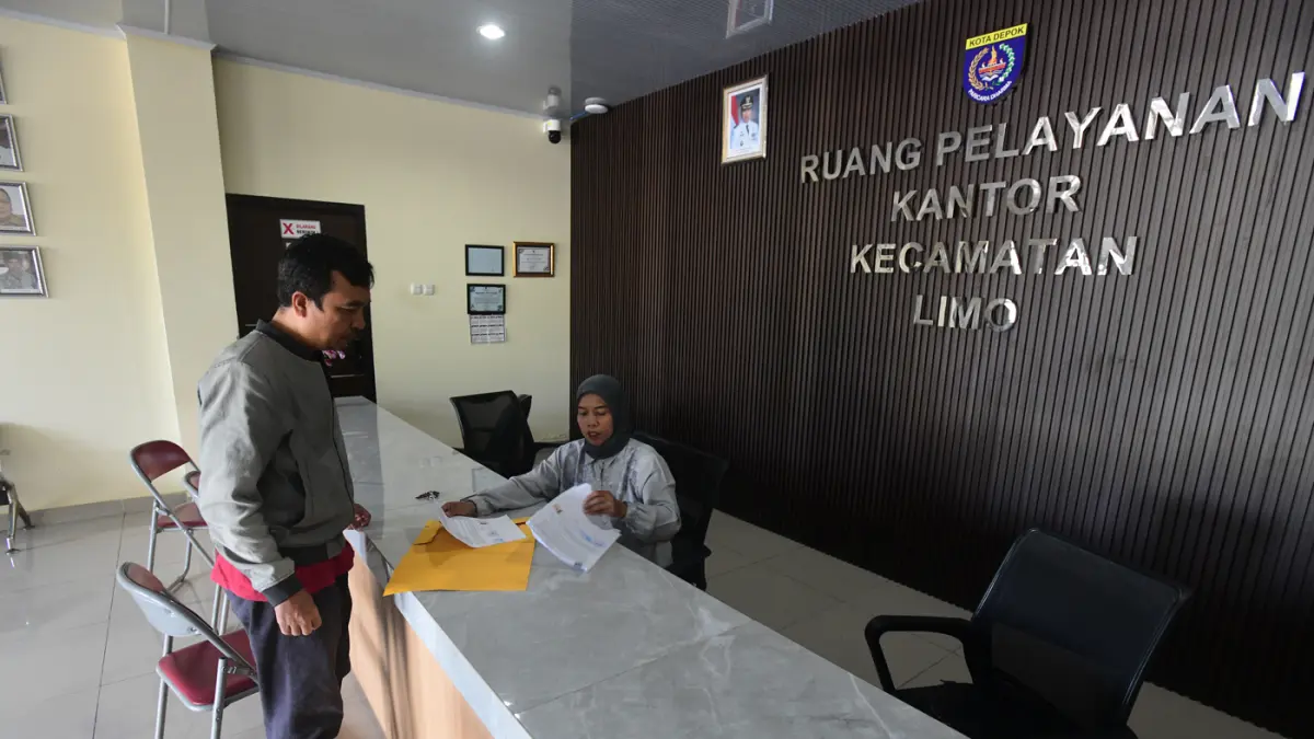 Staf bekerja di depan komputer dengan beberapa meja kursi yang kosong saat penerapan work from home (WFH) bagi aparatur sipil negara (ASN) di kantoir Kecamatan Limo, Depok, Jumat (10/04/2026). (Dery Ridwansah/ JawaPos.com)