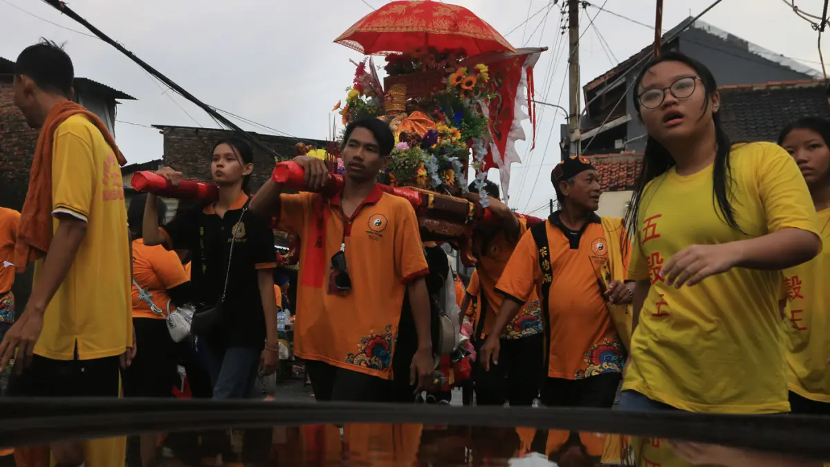 Sejumlah peserta memikul tandu arca berisi patung dewa (Kimsin) saat kirab budaya di kawasan Pecinan Semarang, Jawa Tengah, Minggu (12/4/2026). (Nur Chamim/Jawa Pos Radar Semarang)