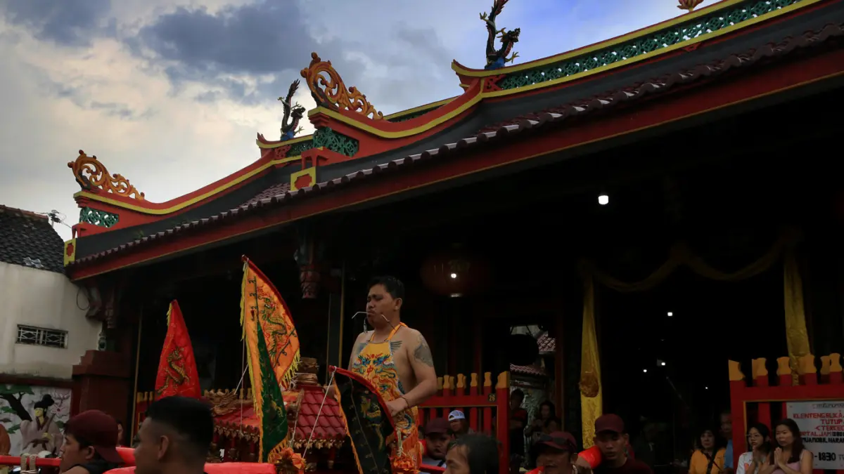 Sejumlah peserta memikul tandu arca berisi patung dewa (Kimsin) saat kirab budaya di kawasan Pecinan Semarang, Jawa Tengah, Minggu (12/4/2026). (Nur Chamim/Jawa Pos Radar Semarang)
