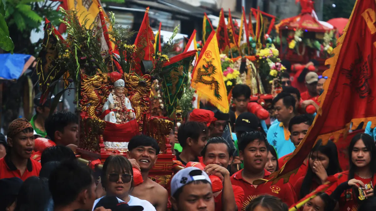 Sejumlah peserta memikul tandu arca berisi patung dewa (Kimsin) saat kirab budaya di kawasan Pecinan Semarang, Jawa Tengah, Minggu (12/4/2026). (Nur Chamim/Jawa Pos Radar Semarang)