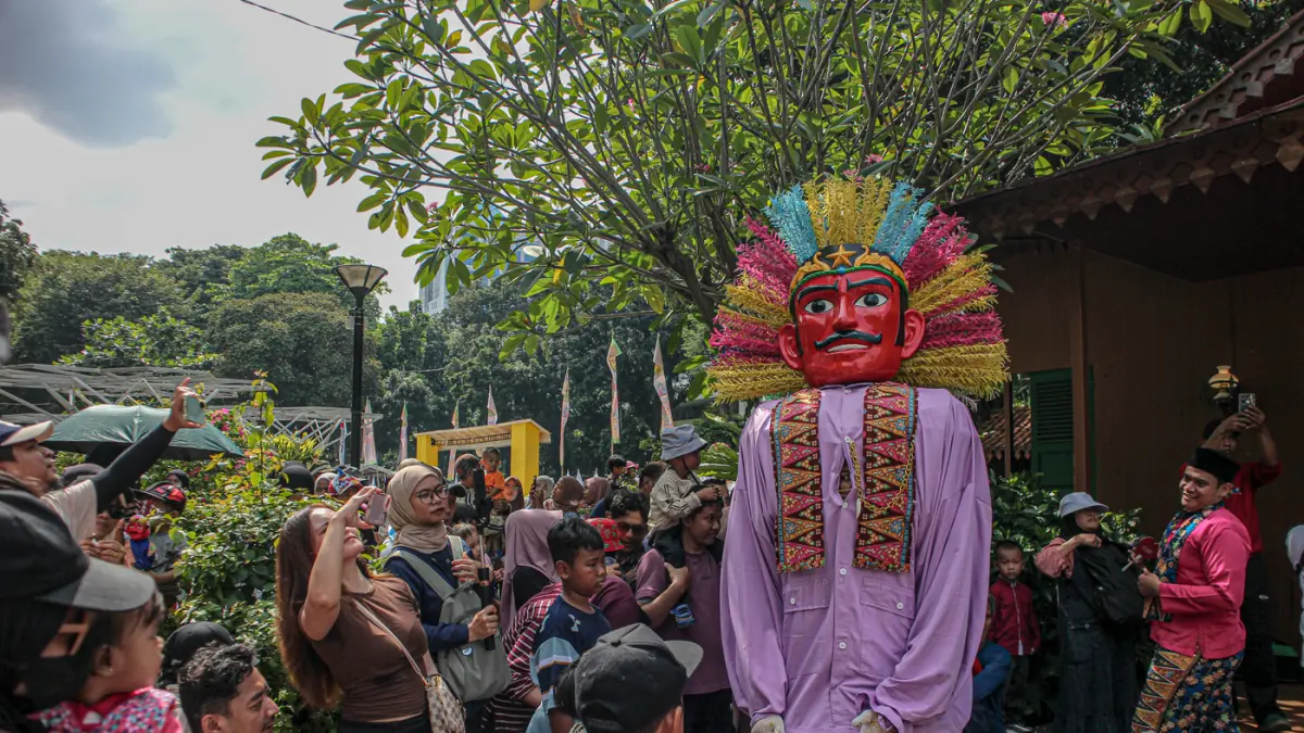 Sejumlah warga melihat petunjunag ondel-ondel saat lebaran Betawi di Lapangan Banteng, Jakarta, Sabtu (11/04/2026). (Hanung Hambara/Jawa Pos)