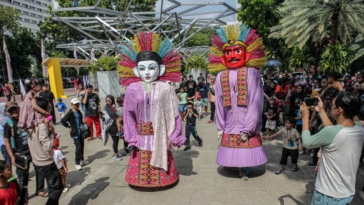 Sejumlah warga melihat petunjunag ondel-ondel saat lebaran Betawi di Lapangan Banteng, Jakarta, Sabtu (11/04/2026). (Hanung Hambara/Jawa Pos)