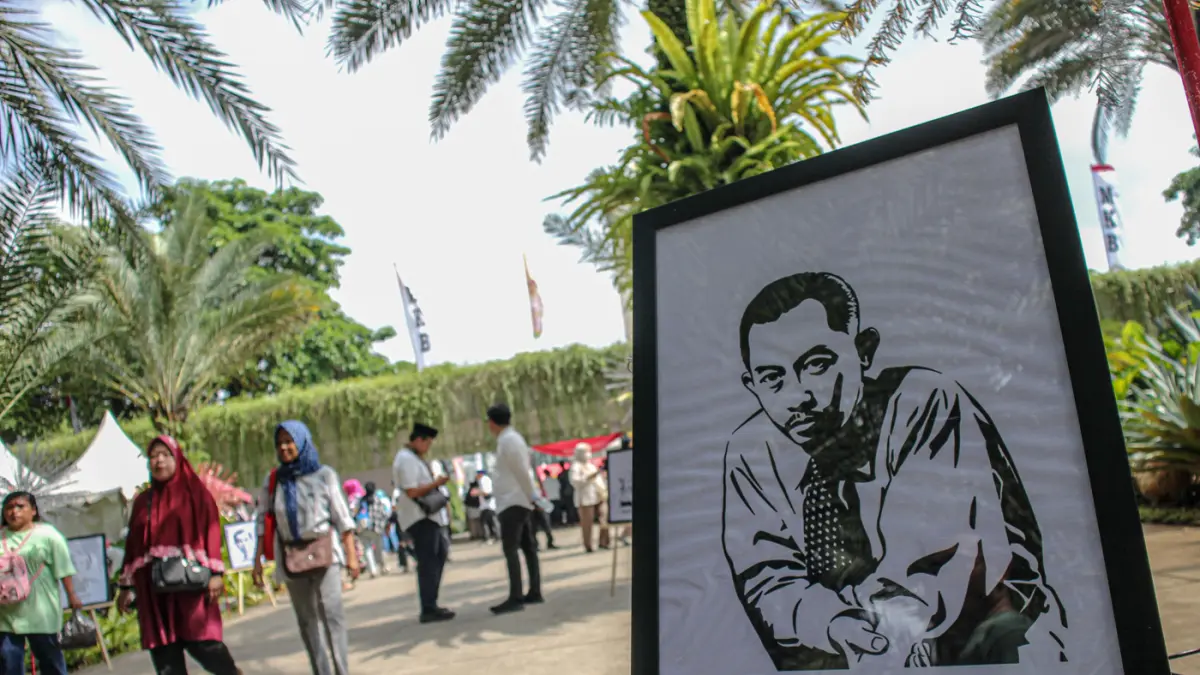 Warga melintas disamping foto toko Betawi yang dipajang saat acara lebaran Betawi di Lapangan Banteng, Jakarta, Sabtu (11/04/2026). (Hanung Hambara/Jawa Pos)