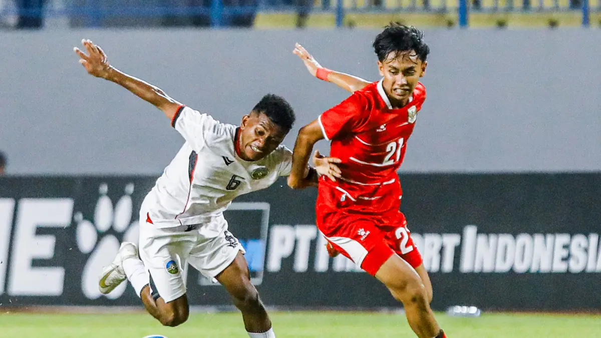 Pemain Timnas Indonesia U-17, Alfredo Nugroho berusaha melewati hadangan pemain Timor Leste U-17 Jeronimo Nono dalam ASEAN U-17 Boys Championship di Stadion Gelora Joko Samudro, Gresik, Senin (13/4) malam. (Riana Setiawan / Jawa Pos)