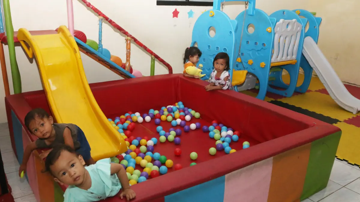 Pendamping menemani anak balita saat minum susu di Rumah Pelita, Manyaran, Semarang, Jawa Tengah, Senin (13/4/2026). (Nur Chamim/Jawa Pos Radar Semarang)
