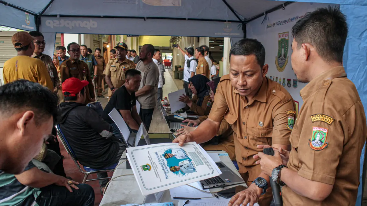Sejumlah pedagang mendaftarkan usaha mereka di Mobil Pendamping On The Spot Layanan Integrasi (POLI) di Pasar Anyar, Kota Tangerang, Selasa (14/04/2026). (Hanung Hambara/Jawa Pos)