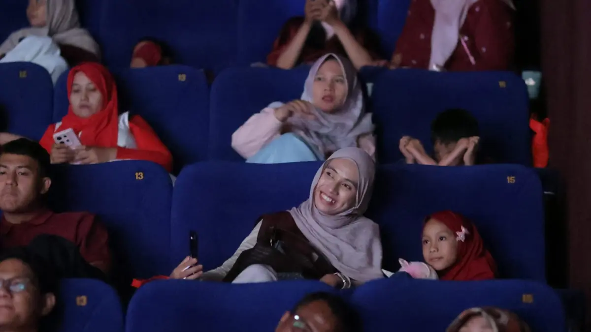 Seorang ibu mendampingi anak saat menikmati film Na Willa dalam kegiatan nonton bareng