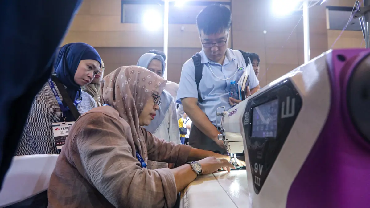 Pengunjung melihat mesin jahit berteknologi AI di stand Hikari pada pameran Indo Intertex & Inatex 2026 di JIExpo Kemayoran, Jakarta, Kamis (16/4/2026). (Salman Toyibi/Jawa Pos)