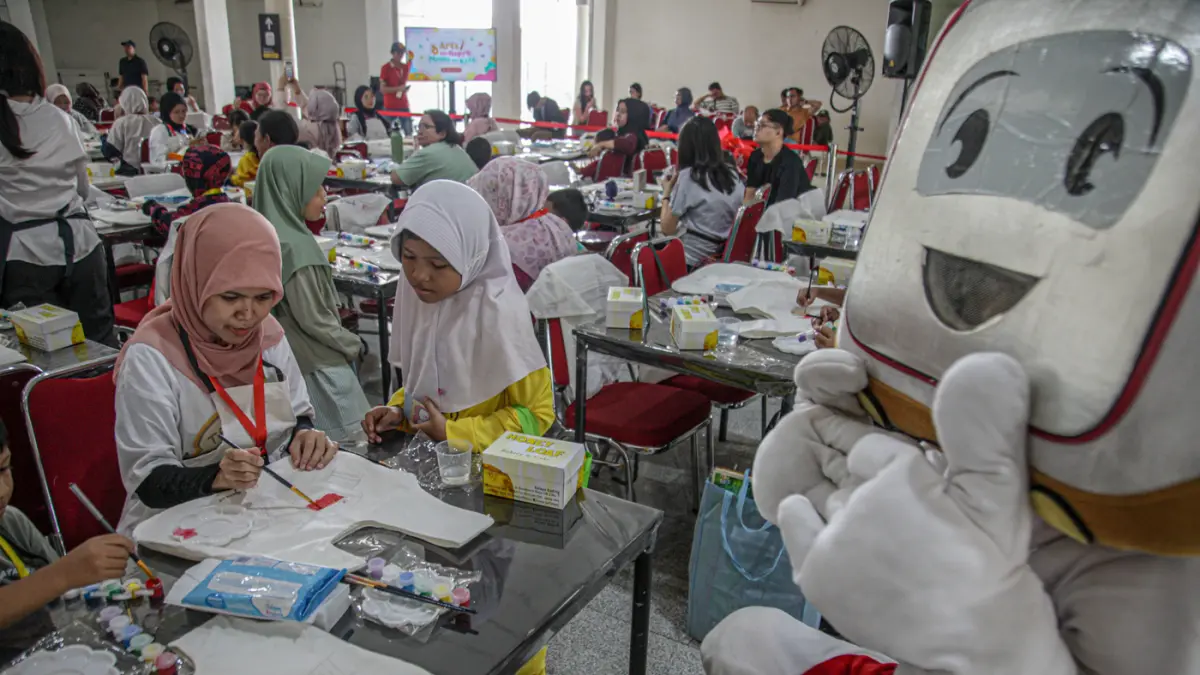 Sejumlah anak-anak didampingi orang tua mewarnai tas kanvas saat kegiatan Re:Art LRT Jakarta Art for Happy Moms and Kids di Stasiun LRT Pulomas, Jakarta, Minggu (19/04/2026). (Hanung Hambara/Jawa Pos)