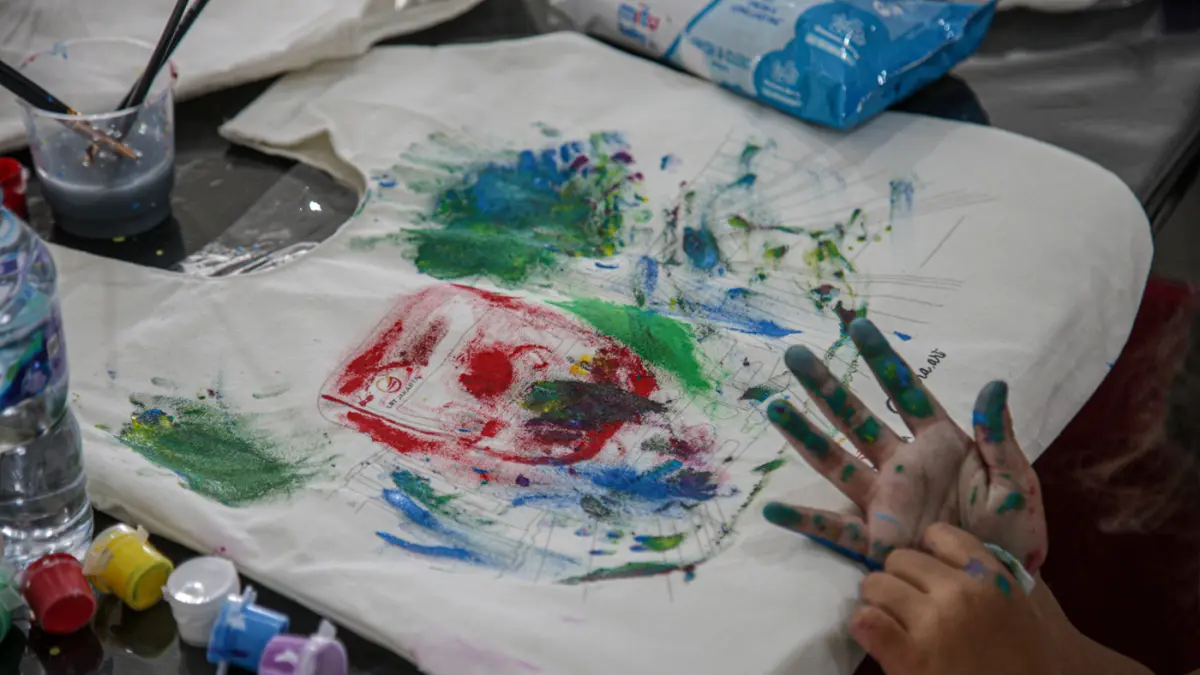 Sejumlah anak-anak didampingi orang tua mewarnai tas kanvas saat kegiatan Re:Art LRT Jakarta Art for Happy Moms and Kids di Stasiun LRT Pulomas, Jakarta, Minggu (19/04/2026). (Hanung Hambara/Jawa Pos)