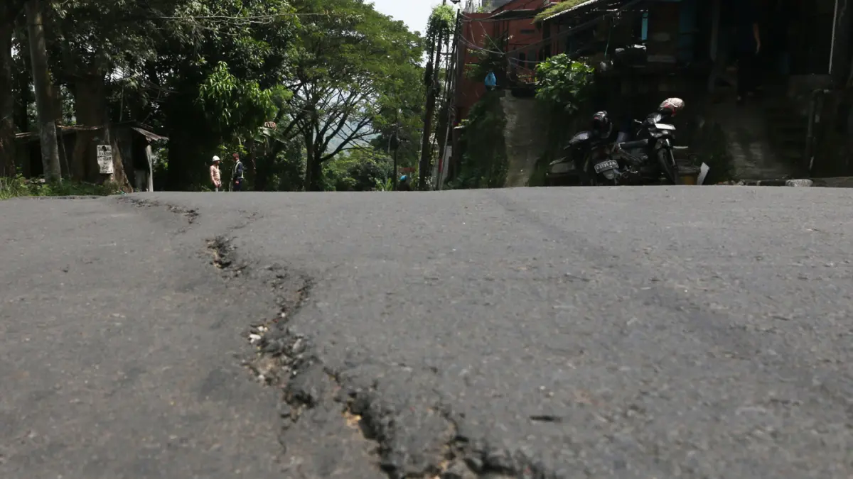 Petugas Kementerian PU memeriksa struktur jalan di Jalan Gombel Lama, Semarang, Jawa Tengah, Senin (20/4/2026). (Nur Chamim/Jawa Pos Radar Semarang)