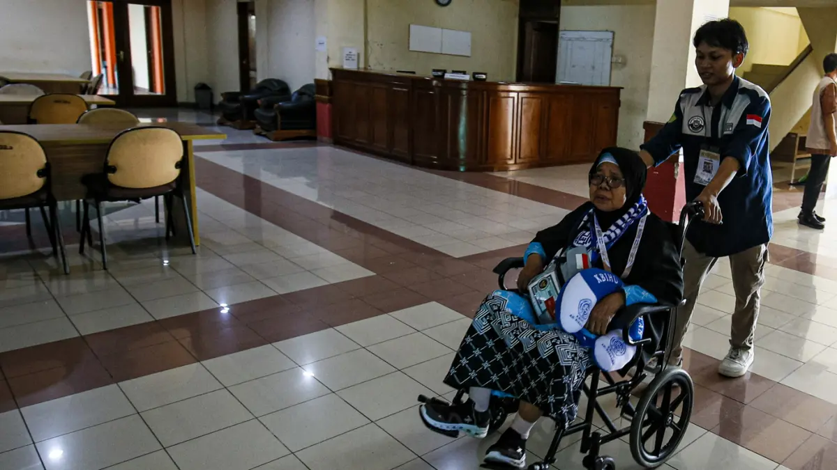 Petugas membantu Jamaah calon haji memasuki kamar di Asrama Haji Pondok Gede, Jakarta, Selasa (21/4/2026). (Salman Toyibi/Jawa Pos)