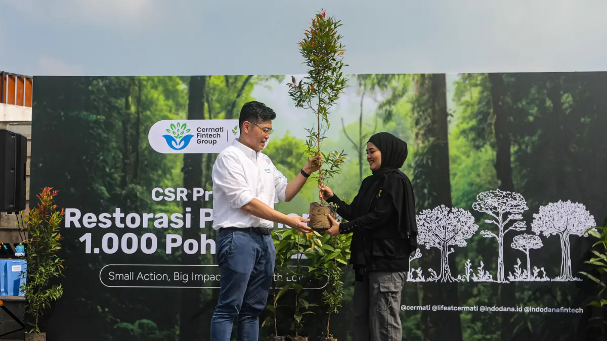 CEO Cermati Fintech Group, Andhy Koesnandar (kiri) bersama Direktur Kertabumi Santi Novianti (kanan) memegang bibit pohon dalam rangka memperingati Hari Bumi bertajuk Zero Carbon di Hutan Kota Eduforest Bekasi, Jawa Barat, Rabu (22/4/2026). (Salman Toyibi