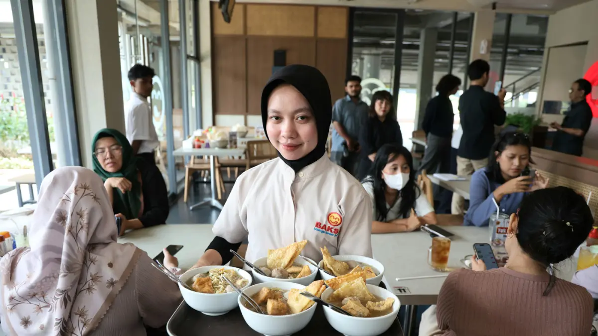 Pelayan mengantar makanan kepada konsumen