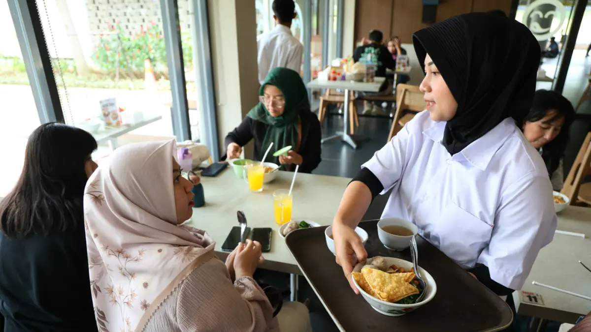 Pelayan mengantar makanan kepada konsumen