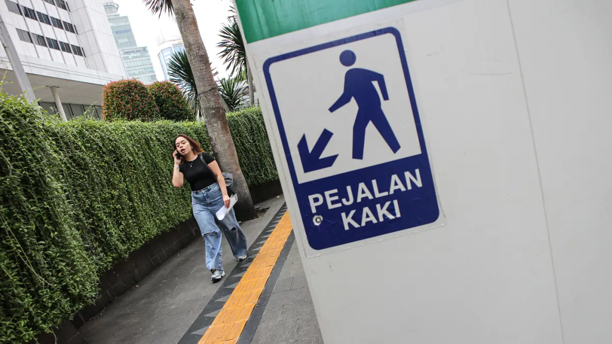Pejalan kaki berjalan di samping proyek revitalisasi area Stasiun MRT BuPekerja konstruksi beraktifitas di proyek revitalisasi area Stasiun MRT Bundaran HI Bank Jakarta di Jalan MH Thamrin, Jakarta, Jumat (24/04/2035). (Hanung Hambara/Jawa Pos)