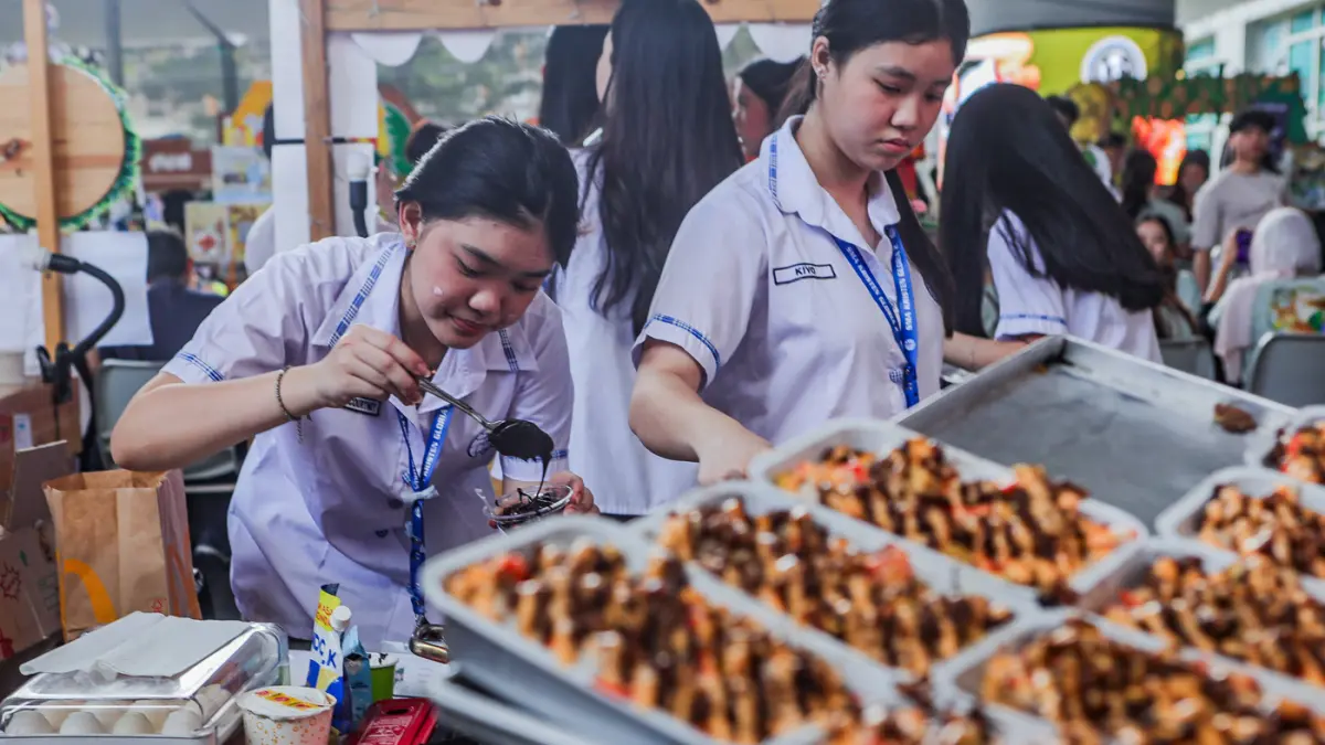 Aktivitas pengunjung dan siswa SMA dari berbagai sekolah di Surabaya belajar enterpreneur dengan berjualan sejumlah makanan daerah hingga internasional saat mengikuti UC Fair & UC Play di area Universitas Ciputra, Sabtu (25/4/2026). (Riana Setiawan/Jawa P
