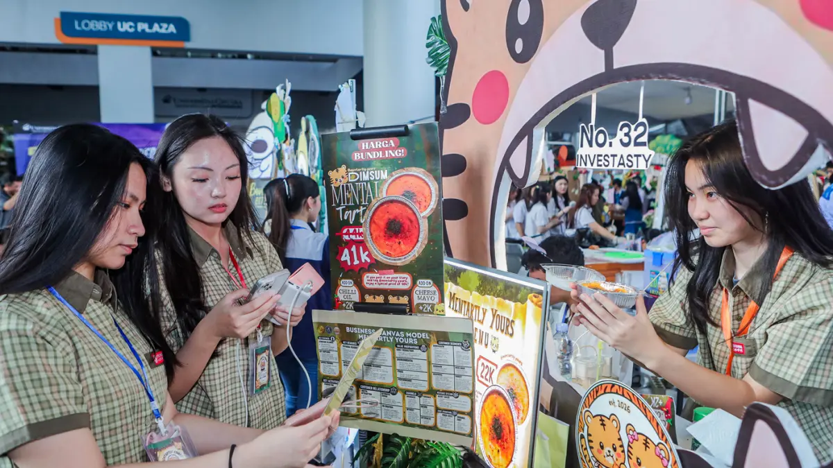Aktivitas pengunjung dan siswa SMA dari berbagai sekolah di Surabaya belajar enterpreneur dengan berjualan sejumlah makanan daerah hingga internasional saat mengikuti UC Fair & UC Play di area Universitas Ciputra, Sabtu (25/4/2026). (Riana Setiawan/Jawa P