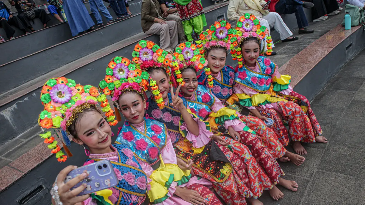 Sejumlah penari berswafoto saat pertunjukan tari Riang Lenggok Betawi Dalam Satu Rasa di Amphitheater UPK Perkampungan Budaya Betawi, Jakarta Selatan, Sabtu (25/04/2026). (Hanung Hambara/Jawa Pos)