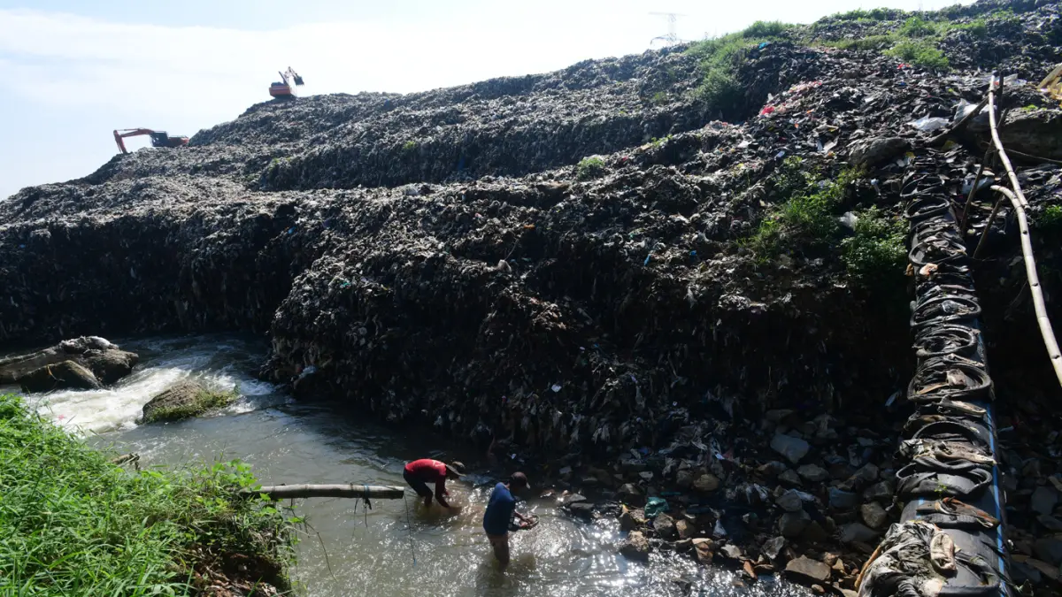 Warga mendulang benda-benda logam pada aliran Kali Pesanggrahan yang menyempit alibat longsoran timbunan sampah TPA Cipayung di kawasan Pasir Putih, Depok, Jawa Barat, Senin (27/04/2026).