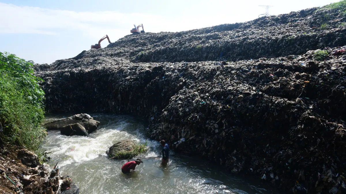 Warga mendulang benda-benda logam pada aliran Kali Pesanggrahan yang menyempit alibat longsoran timbunan sampah TPA Cipayung di kawasan Pasir Putih, Depok, Jawa Barat, Senin (27/04/2026).