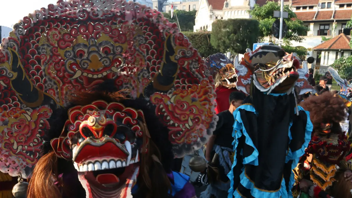 Warga menyambut kemeriahan Karnaval Seni Budaya Lintas Agama atau Pawai Ogoh-ogoh melintas di lawang sewu Kota Semarang (26/4/2026). (Nur Chamim/Jawa Pos Radar Semarang)