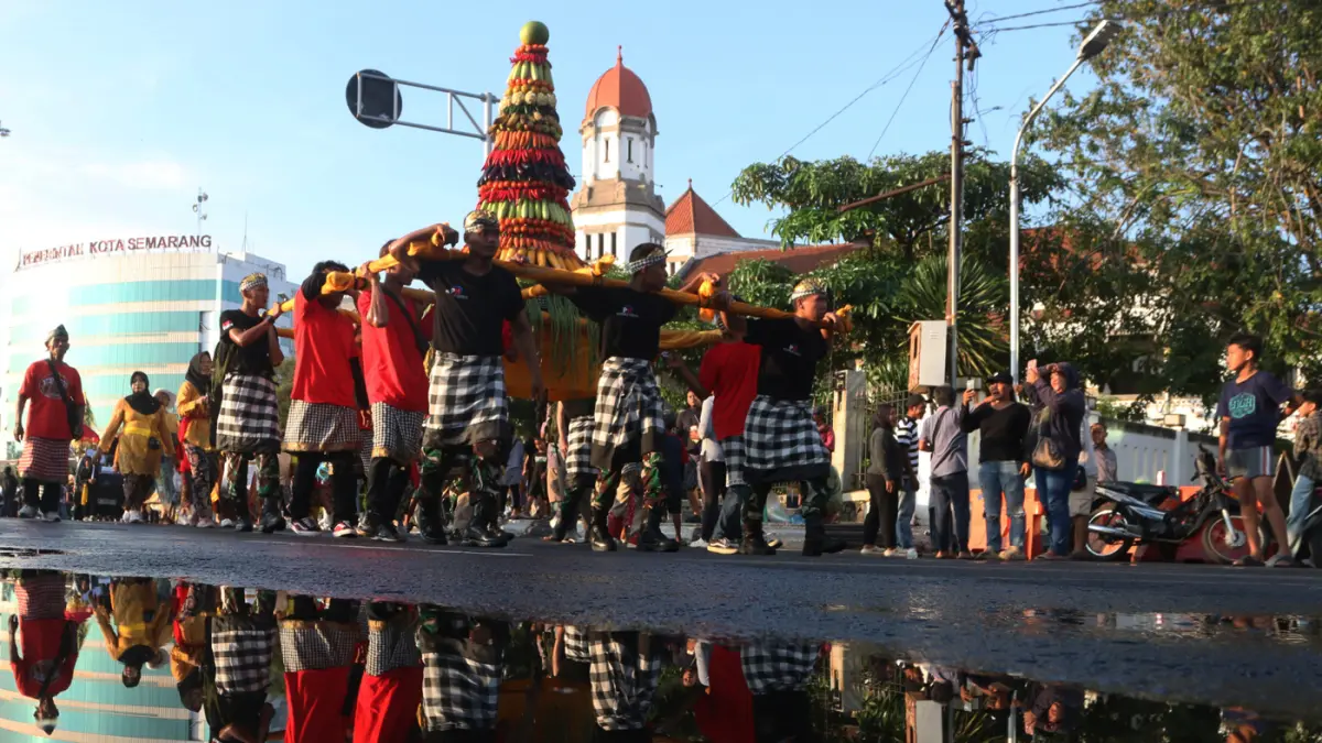 Warga menyambut kemeriahan Karnaval Seni Budaya Lintas Agama atau Pawai Ogoh-ogoh melintas di lawang sewu Kota Semarang (26/4/2026). (Nur Chamim/Jawa Pos Radar Semarang)