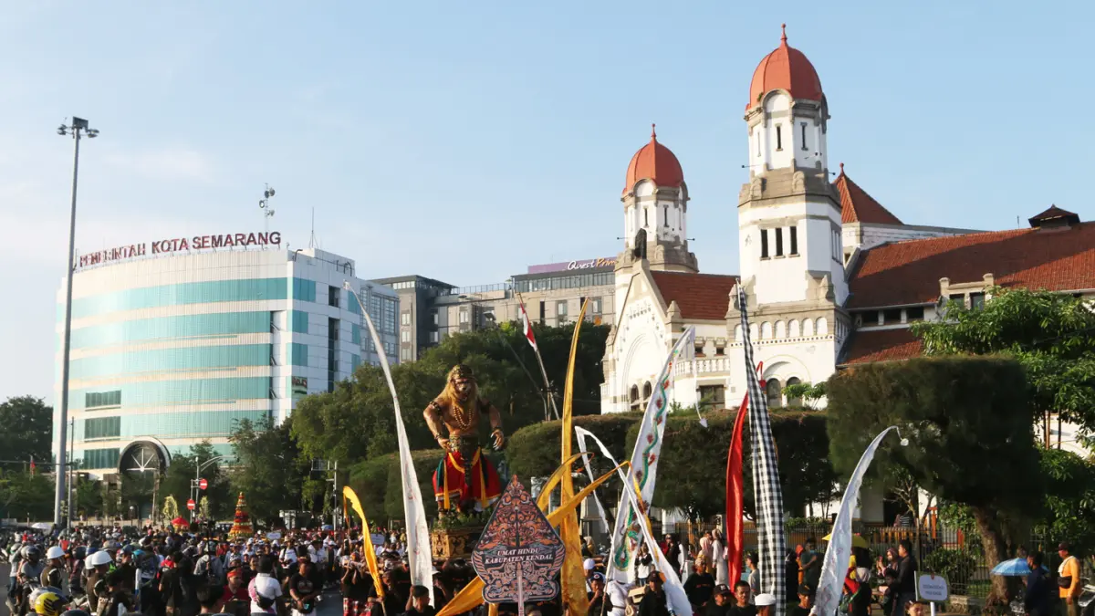 Warga menyambut kemeriahan Karnaval Seni Budaya Lintas Agama atau Pawai Ogoh-ogoh melintas di lawang sewu Kota Semarang (26/4/2026). (Nur Chamim/Jawa Pos Radar Semarang)